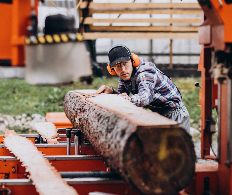 Tartak, mężczyzna przygotowuje drewno - przykład strategii w firmie produkcyjnej